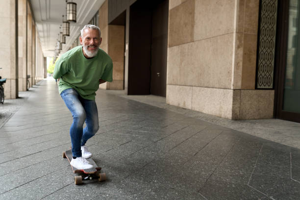 도시 거리에서 스�케이트 보드를 타는 활동적인 행복한 멋진 노인 스케이터. - skateboarding skateboard extreme sports sport 뉴스 사진 이미지