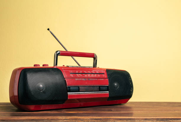 Retro red old portable radio cassette recorder in front of yellow concrete wall. Retro red old portable radio cassette recorder in front of yellow concrete wall. audio electronics stock pictures, royalty-free photos & images