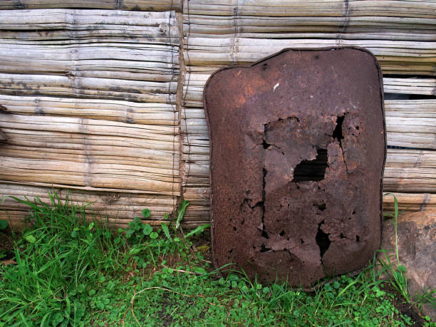 A very old and rusty wheelbarrow laying against a cane wall in a farm near the colonial town of Villa de Leyva in central Colombia.