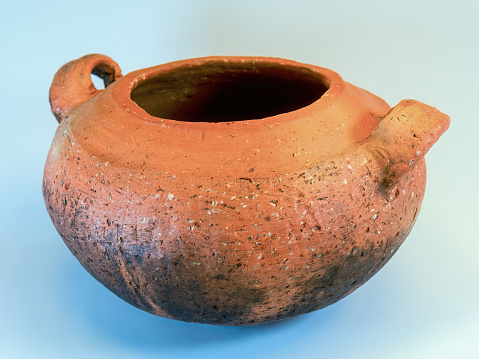 Studio shot of an old used traditional clay cooking pot on a neutral background