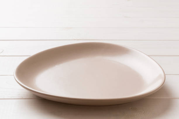 istock Perspective view of empty pink plate on wooden background. Empty space for your design 1424295048