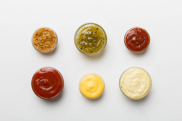 istock Different types of sauces in bowls on a colored Board . Top view. various sauces copy space 1424295093