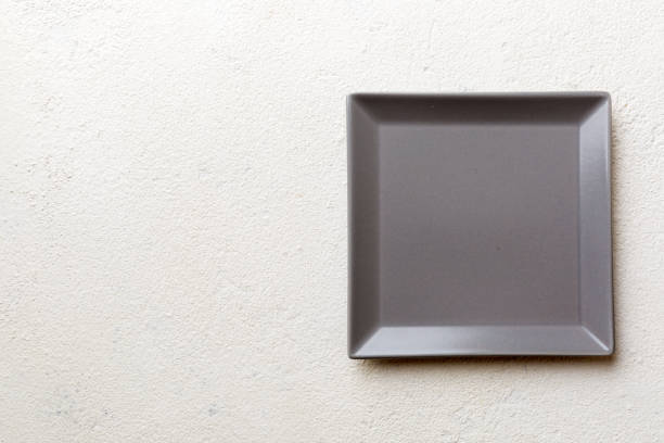 istock Top view of empty square plate on cement background. Empty space for your design 1424295203