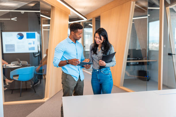 istock Two business colleagues talking in office hallway 1424296357