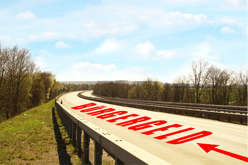 Arrow sign text to Buergergeld. Word at empty road, Highway. changes for the unemployed in germany. Citizens allowance, Supplementary Welfare Allowance instead of Hartz IV concept. No cars