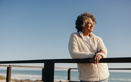 Mujer mayor disfrutando de una vista refrescante en la playa photo