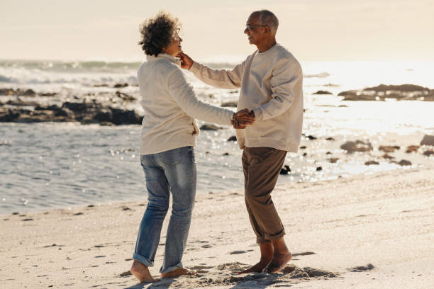 istock Happy elderly couple dancing together at the beach 1424300302