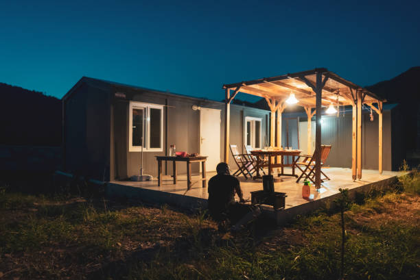 istock Mature man preparing barbecue dinner in backyard of container house. 1424303446