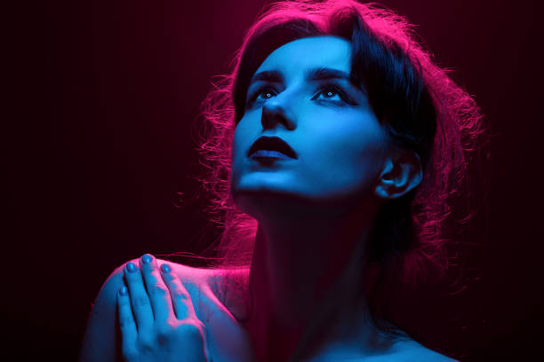 istock woman in multicolor lights 1424303536