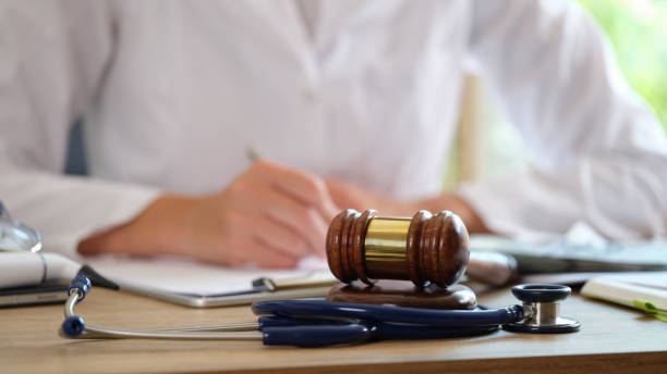 istock Court gavel with stethoscope on a table in background doctor writes notes 1424304067