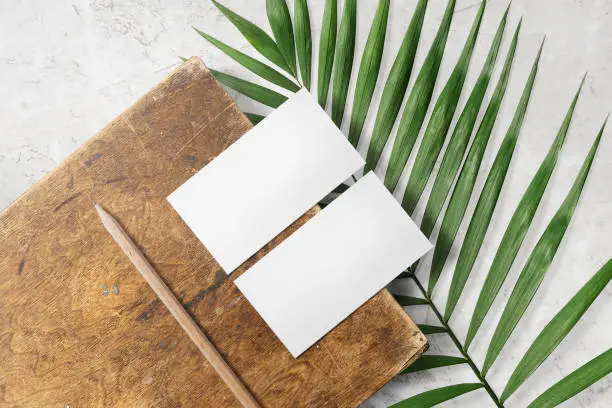 Photo of Clean minimal business card mockup on wood plate with leaves and pencil