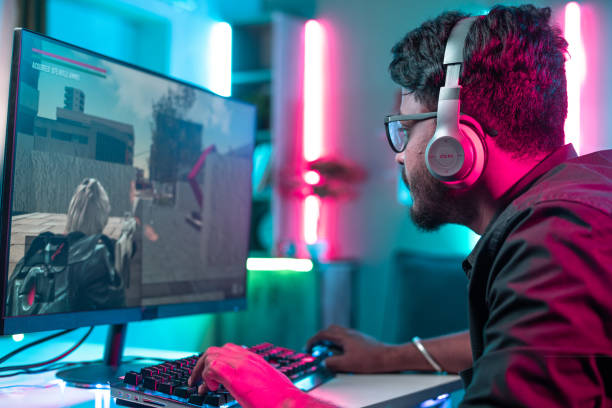 istock gamer with wireless headset playing online video game on computer pc at home - concept of concentration, online video gaming and competition. 1424304885
