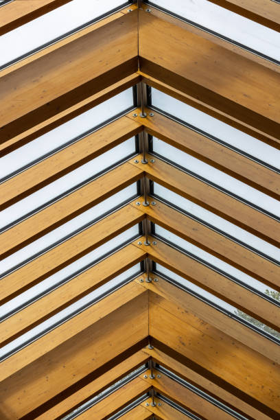istock Exposed wooden truss rafters supporting glass skylight roof 1424307105