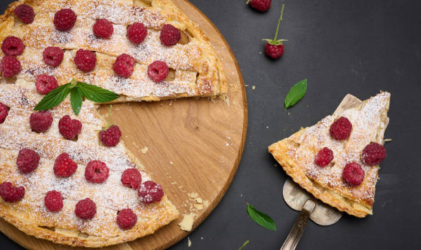 istock Round baked pie with apples and sprinkled with powdered sugar on a black table. 1424308053