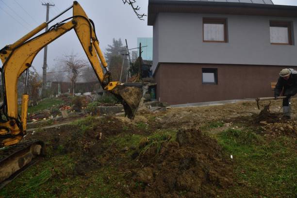 istock A mason worker works on a construction site while an excavator dredges hole for cesspool 1424309675