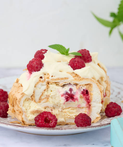 istock Baked meringue roll with cream and fresh red raspberry, white background 1424312904