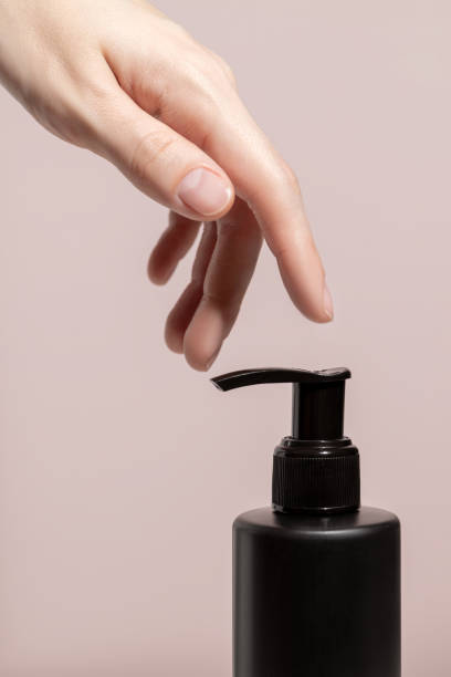 istock A womans hand and black dispenser with a cream. Mockup. 1424313791