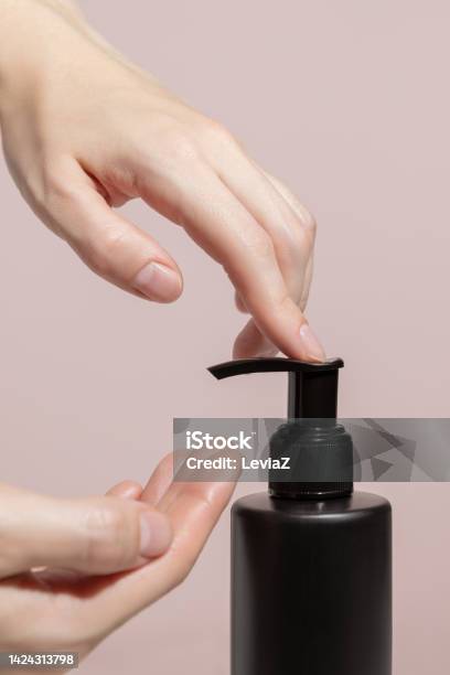 Womens Hands Press On A Black Dispenser With A Liquid Tonic Stock Photo - Download Image Now