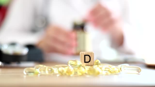 Doctor prescribing yellow gelatin capsules of vitamin d 4k movie slow motion