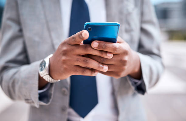 istock Businessman hands with phone on internet, web or email app organizing work schedule in the city. Entrepreneur texting contact on social media with a mobile smartphone or 5g device in a urban town 1424330049