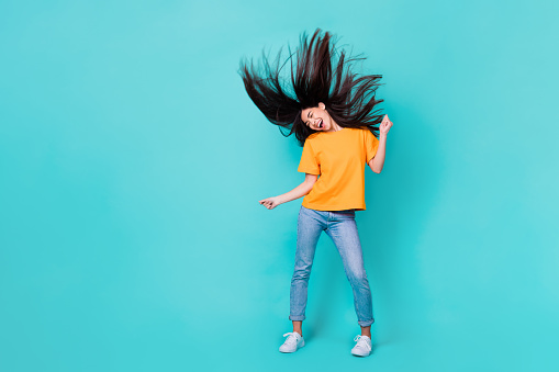 Full length photo of funny brunette lady dance wear t-shirt jeans shoes isolated on turquoise color background.