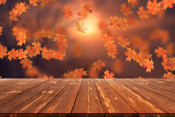 istock Idyllic blurred autumn landscape with fall leaves and empty wooden table 1424332890