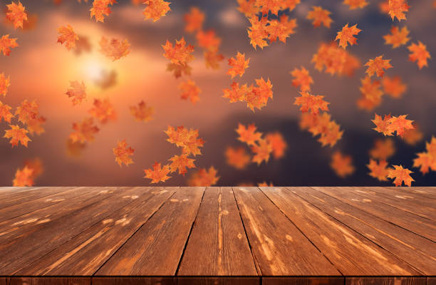 istock Idyllic blurred autumn landscape with fall leaves and empty wooden table 1424333064