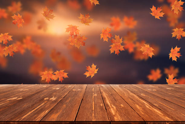 istock Idyllic blurred autumn landscape with fall leaves and empty wooden table 1424333309