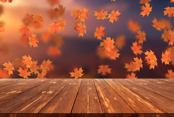 istock Idyllic blurred autumn landscape with fall leaves and empty wooden table 1424333421