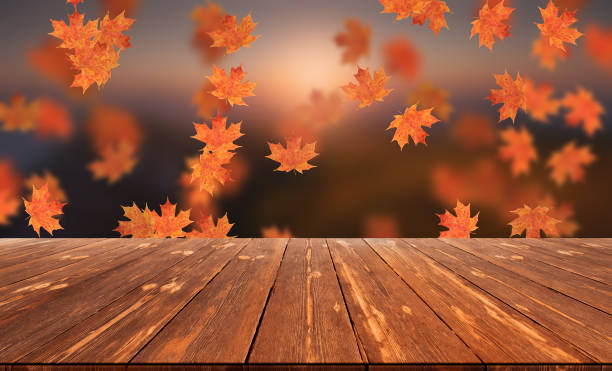 istock Idyllic blurred autumn landscape with fall leaves and empty wooden table 1424333470