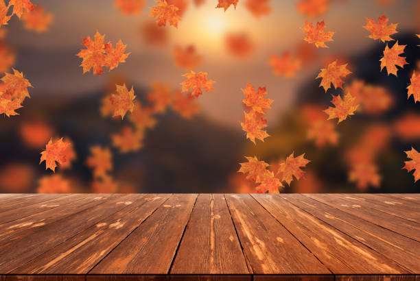 istock Idyllic blurred autumn landscape with fall leaves and empty wooden table 1424333506