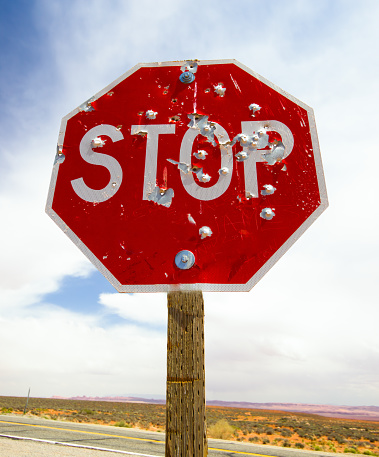 Stop sign marked by several gunshots