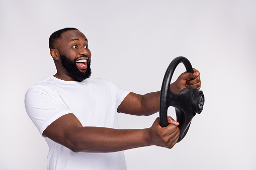 Photo of excited funny man wear casual t-shirt riding automobile looking empty space isolated white color background.