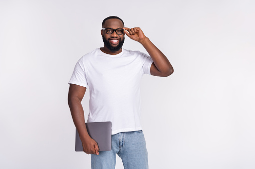 Photo of confident cute man wear casual t-shirt arm spectacles holding modern device isolated white color background.