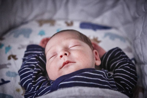 Close-up view of a newborn baby boy sleeping in a crib
