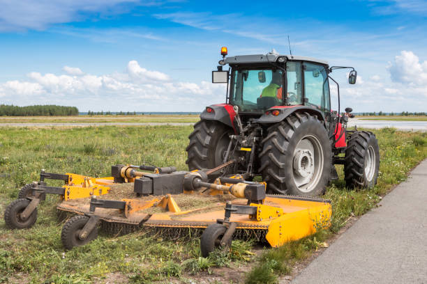 tractor de ruedas con cortadora de césped junto a la carretera - maquinaria agrícola fotografías e imágenes de stock