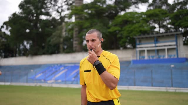 Referee whistling during soccer match