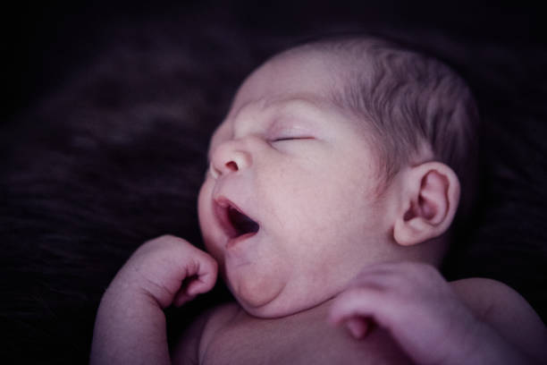 Close-up of a newborn baby boy yawning
