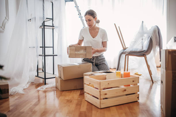 istock Woman unpacking in new home 1424343690