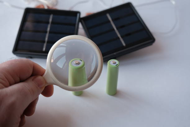 istock rechargeable batteries and mini solar panel. AA battery charger based on solar panels. free solar power for small green projects 1424348384
