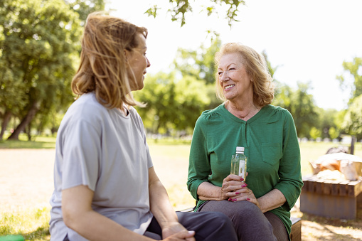 Two active senior females talking and having fun after outdoor exercise