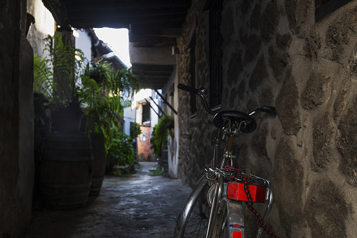 Old bicycle in narrow and dark alley, concept of ecological transport
