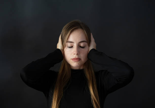 Blond woman with closed eyes covering her ears with her hands. Blond woman with closed eyes covering her ears with her hands.
She is from Russia.
Indoor Photoshoot. berk stock pictures, royalty-free photos & images