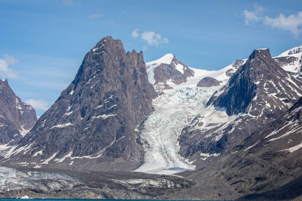 Large glacier flowing down mountain side to the sea at Evighedsfjord, Greenland stock photo