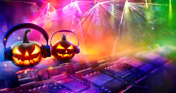Halloween Disco Music - Pumpkins With Headphones In Nightclub With Confetti And Defocused Abstract Lights stock photo