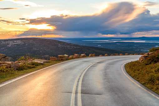 An Autumn sunset view of winding Cadillac Summit Road near top of Cadillac Mountain in Acadia National Park, Bar Harbor, Maine, USA. Note: main focus is on the winding road.