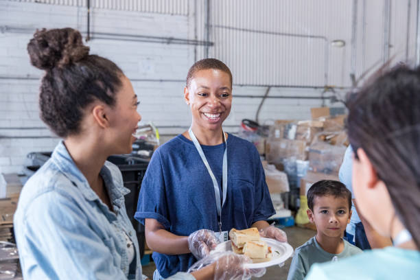 istock Volunteers smiling as they serve meals 1424369192