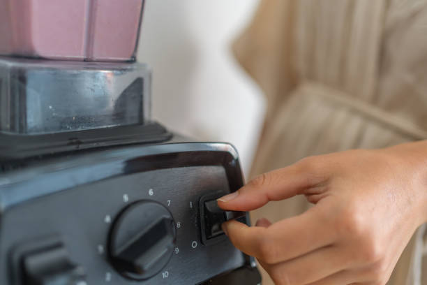 istock Young woman prepares a breakfast smoothie in blender 1424370992