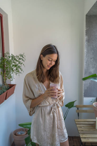 istock Young woman enjoys a breakfast smoothie 1424371073