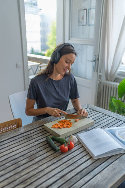 istock Young woman listens to audio recording while cooking 1424371453